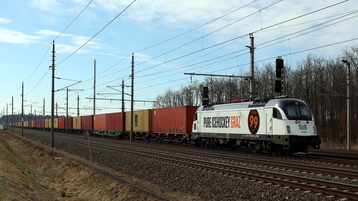 1216 960 der Steiermarkbahn mit Containerzug vor dem Cargo Center Werndorf (Stmk.). Hier mit der Werbebeklebung fr den Grazer Eishockeyklub. 21.03.2021