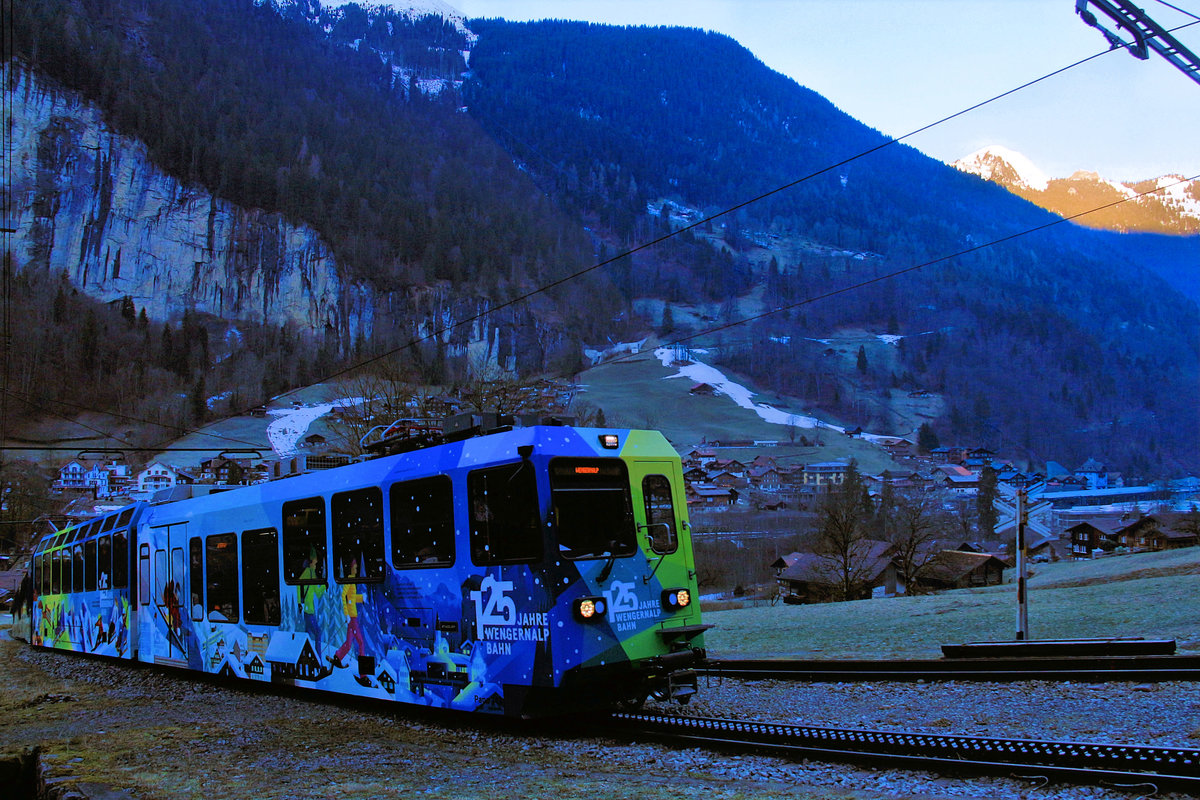 125 Jahre Wengernalpbahn in der eisigen Morgenfrühe; noch ist die fürchterlich zähe Nebeldecke unter dem ersten Licht auf den Gipfeln sichtbar. Panorama-Triebwagen 143. 13.Januar 2018. 