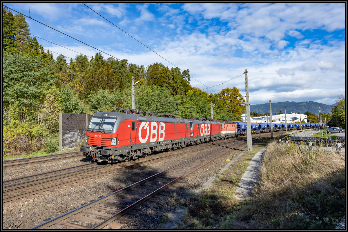 1293.075 führt einen Güterzug gen Süden an . Hier bei Villach Warmbad an diesem sonnigen 14.10.2021