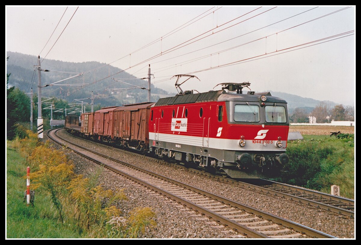 13 Jahre wurde die 1044 208 als Werbelok genützt. Sie trug von 1993 bis 2006 an den Seitenwänden eine dezente Werbung für  Rail Cargo Ausrtia . Hier zu sehen mit Güterzug bei Oberaich am 1.10.2002.