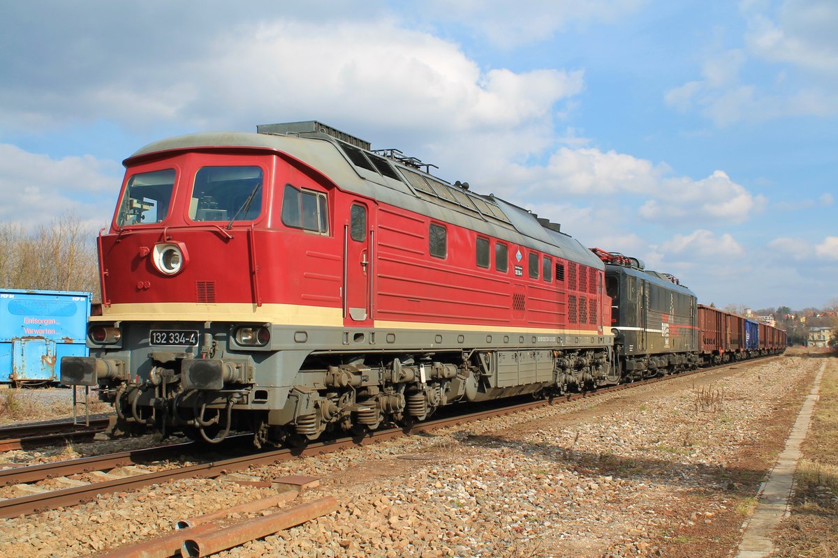 132 334-4 und 155 007-8 (beide EBS) mit einem Holzzug am 9.3.2021 beim Kreuzungshalt in Pößneck oberer Bahnhof