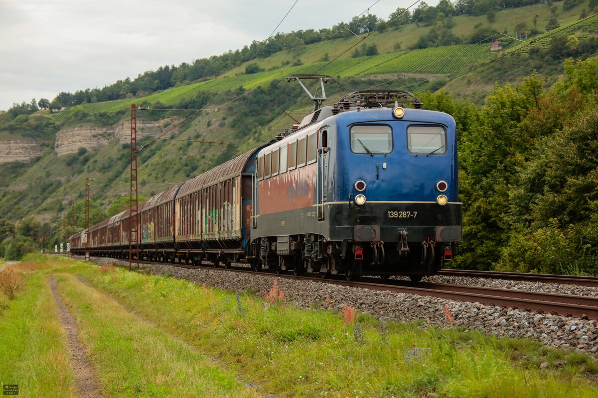 139 287-7  BayernBahn  mit Henkelzug in Thüngersheim, August 2021.