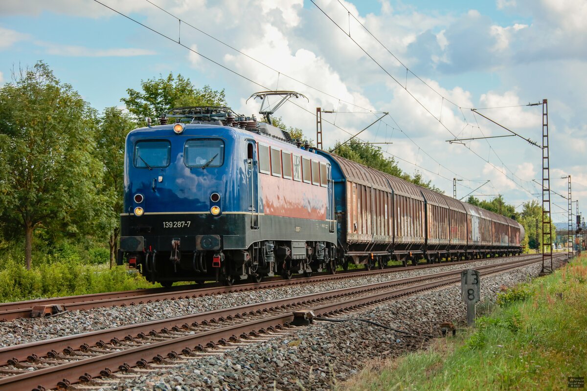 139 287-7  BayernBahn  mit Henkelzug in Thüngersheim, August 2021.