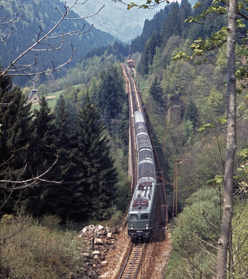 139 561 auf dem Ravennaviadukt mit dem ehemaligen Bahnhof Höllsteig im Hintergrund. Rechts erkennt man ein Widerlager des alten Ravennaviadukts, der in einer Kurve lag (4.5.1979).