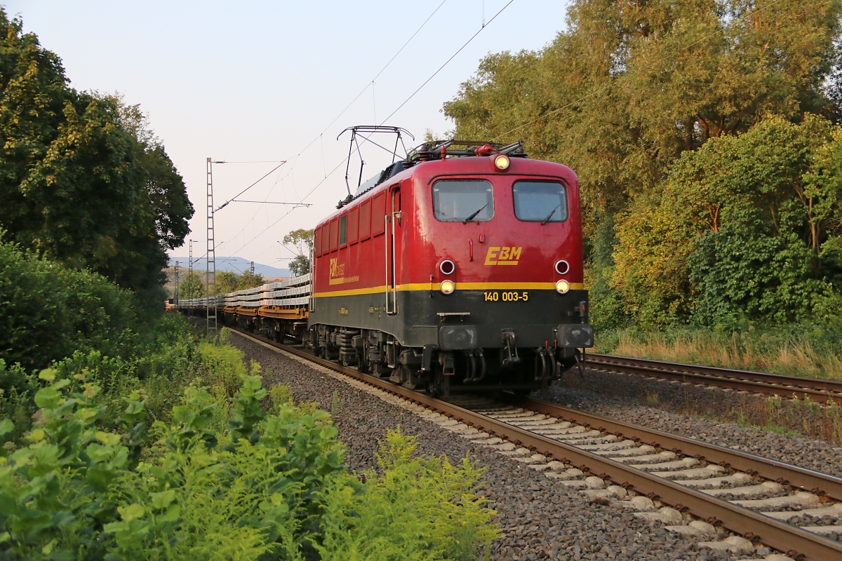 140 003-5 der EBM mit Betonschwellen auf Flachwagen in Fahrtrichtung Süden. Aufgenommen in Wehretal-Reichensachsen am 11.08.2015.