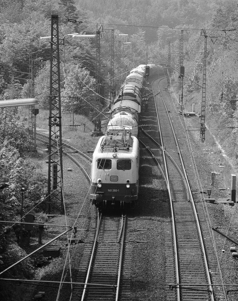 140 260 unterstützt durch 194 581 hat das Ende der Spessartrampe erreicht und wird gleich mit einem Pfiff im Schwarzkopftunnel verschwinden (10.8.1983).