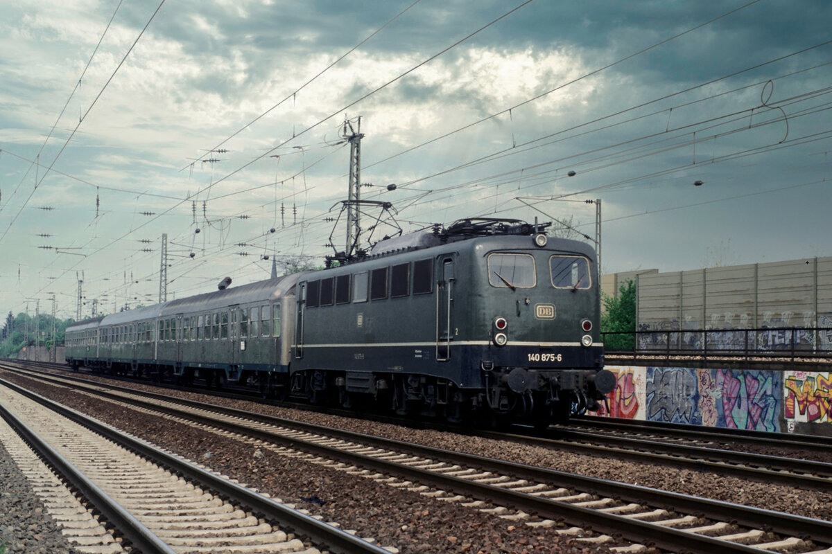 140 875 in grün am 25.04.1993 auf der Fahrt von Mannheim nach Heidelberg bei Mannheim-Friedrichsfeld.