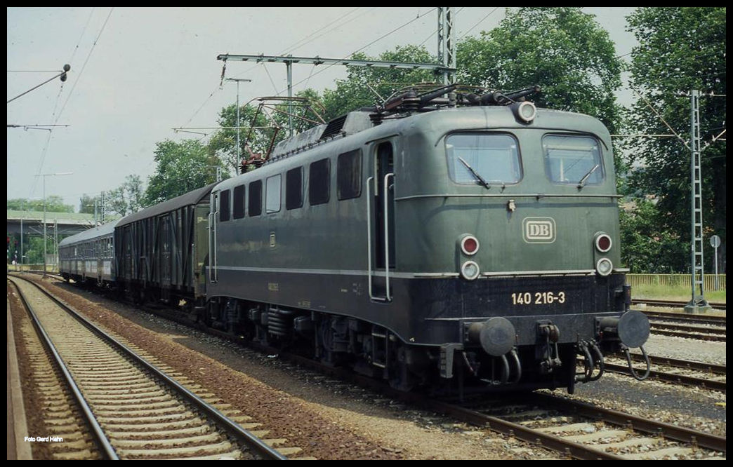 140216 mit einer interessanten Wagen Garnitur im Bahnhof Osterburken am 8.7.1991.Ein Behelfspackwagen und zwei Silberlinge als Werbeträger waren damals schon etwas Besonderes. Die grüne 140zig macht die interessante Garnitur komplett!