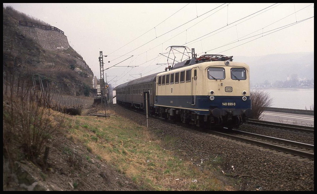 140699 ist hier am 10.3.1993 um 11.19 Uhr linksrheinisch mit einem Nahverkehrszug nach Ludwigshafen nahe Boppard unterwegs.