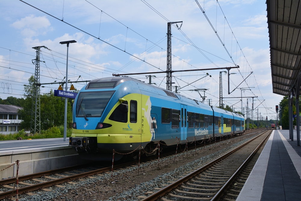 14.07.2017, Bahnhof Bad Bentheim. Flirt von Westfalenbahn als RB 61 nach Bielefeld Hbf wartet auf Abfahrt. Im Hintergrund gibt es BR 101 035-4, die mit dem IC 143 nach Berlin Ostbahnhof fahren wird.