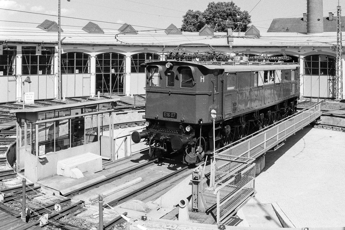 14.08.1956? Nein, 60 Jahre später steht E16 07 auf der Drehscheibe des Bw Freilassing. 14.08.2016
Analogaufnahme auf Ilford HP5 (400 ASA), Nikon F501, 35mm, 1/250s, f/11, Digitalaufnahme vom Negativ

Hersteller: Krauss-Maffei (mrchanischer Teil), Brown Boveri (elektrischer Teil
Fabriknummer: 8172 (Krauss-Maffei), 5045 (Brown Boveri)
Baujahr: 1927
Erst-Bw: Freilassing
Betreibernr. z.Z.d. Aufnahme: E16 07
ursprüngl. Fahrzeugnr.: E16 07
Umzeichnungen: 116 007-6 (01.01.1968)
z-Stellung (DB): 05.02.1974
Ausmusterung (DB):  01.05.1974