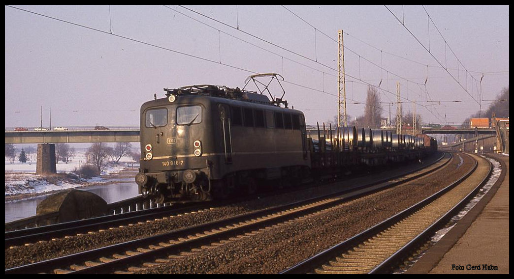 140846 fährt hier am 20.2.1991 um 15.35 Uhr an der Weser entlang mit einem Coil Zug in Richtung Westen durch den Bahnhof Porta Westfalica