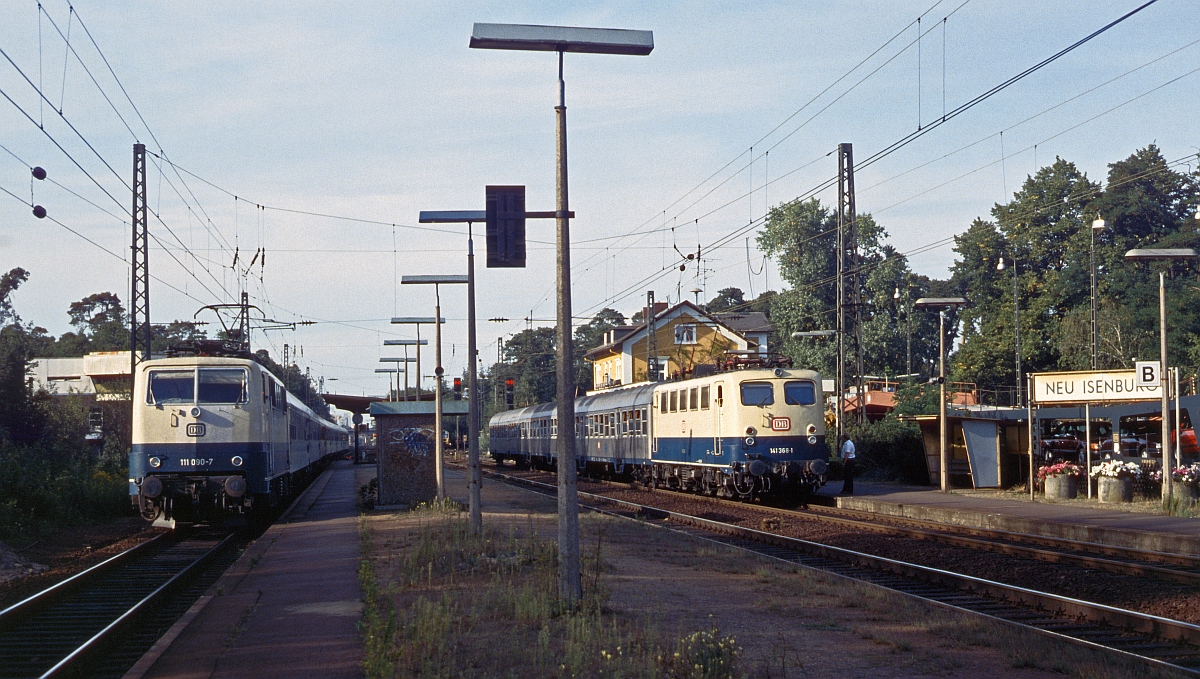 141 368 mit Nahverkehrszug nach Darmstadt wird in Neu Isenburg von 111 090 mit einem IR berholt. Aufnahme vom Juli 1983 vor dem S-Bahn-Bau.