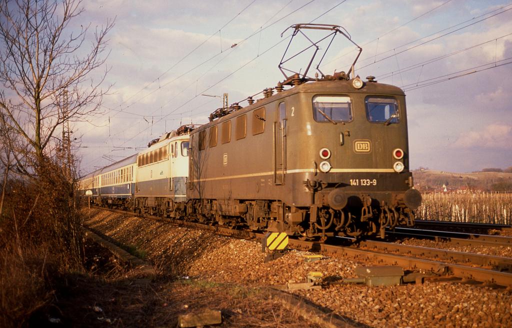 141133 mit 110296 und dem E 3455 am Haken am 4.3.1989 um 17.14 Uhr bei Müllheim (Baden) in Richtung Basel.