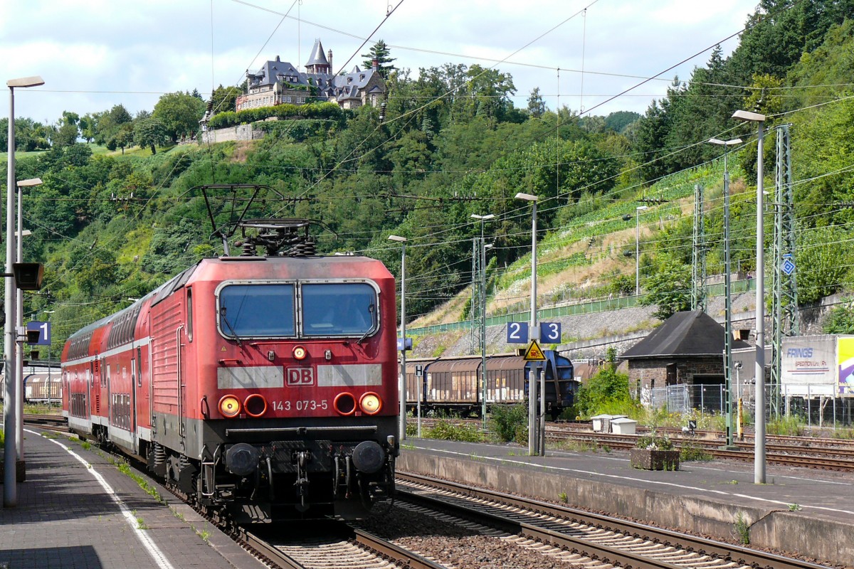 143 073-5 erreicht mit ihrer RB Linz am Rhein. Im Hintergrund thront auf der Anhöhe Burg Ockenfels. Die Aufnahme stammt vom 28/07/2009.