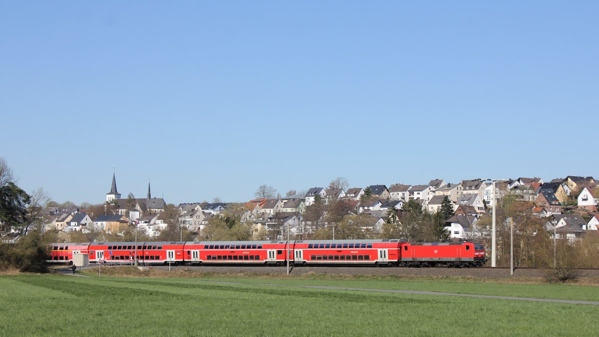 143 228 fährt am 24.03.2020 mit der Regionalbahn RB 15263 von Limburg (Lahn) nach Frankfurt (Main) aus Niederbrechen aus. Während die Bahnstrecke durch den Goldenen Grund durchs Tal am Emsbach entlang verläuft, liegt der Ort Niederbrechen mit ehemaligem Stadtkern und Kirche zu großen Teilen am Hang.