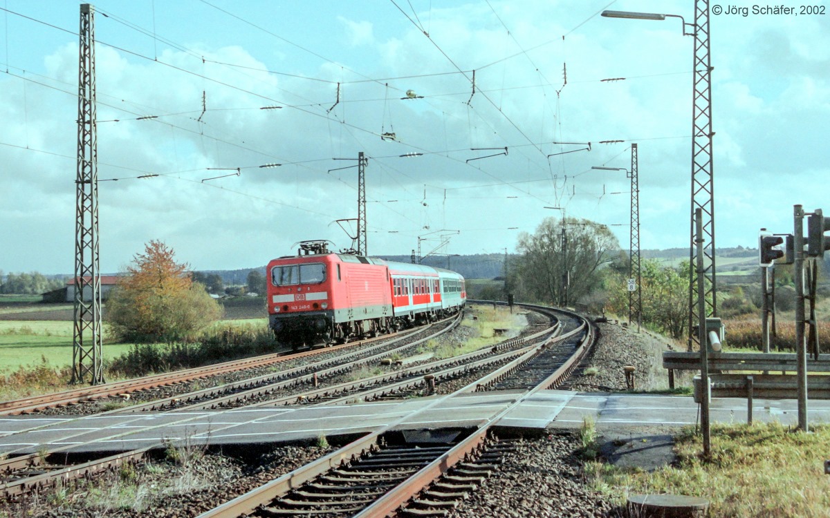 143 240 erreichte am 18.10.02 mit einer Regional¬bahn nach Würzburg den Bahnübergang der Straße nach Hürbel bei km 58,8. Im Rücken des Fotografen lag der Bahnhof Lehrberg.