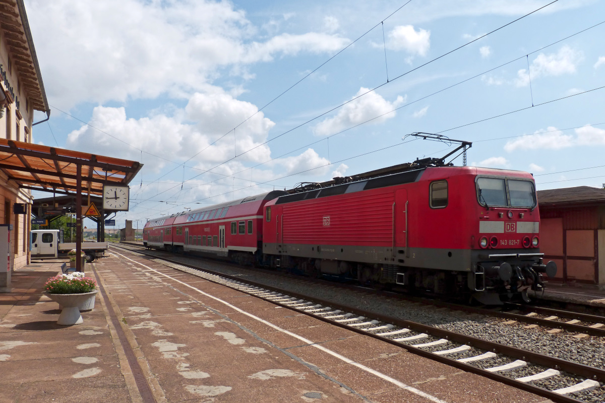 143 821-7 im Bahnhof Bleicherode Ost. Schönes Nebenbei ist der bepflanzte Blumenkübel links, sowas findet man nur noch selten an Bahnhöfen im Vergleich zu früher. 15.07.2015