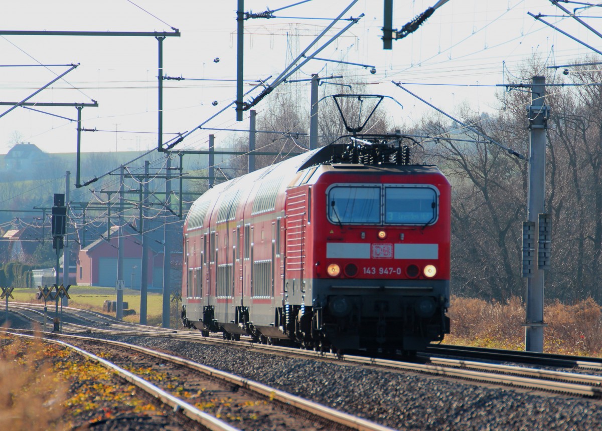 143 947-0 kommt am 16.12.2013 mit dem RE 3 (RE 4767) aus Hof nach Dresden Hbf durch die Ortschaft Mosel b. Zwickau gefahren, nächster Halt ist Glauchau (Sachs).
