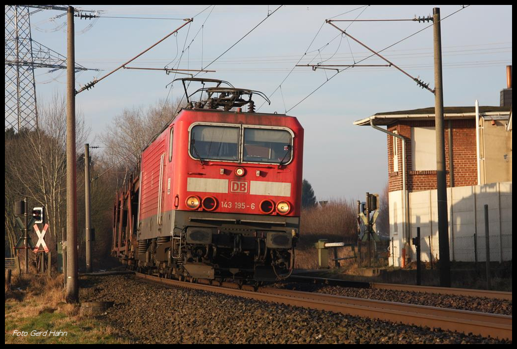 143195 passiert hier am 16.2.2017 um 8.51 Uhr mit einem leeren Autotransportzug den ehemaligen Schrankenposten an der Velper Straße am Ortsrand von Lotte in Richtung Osnabrück. 