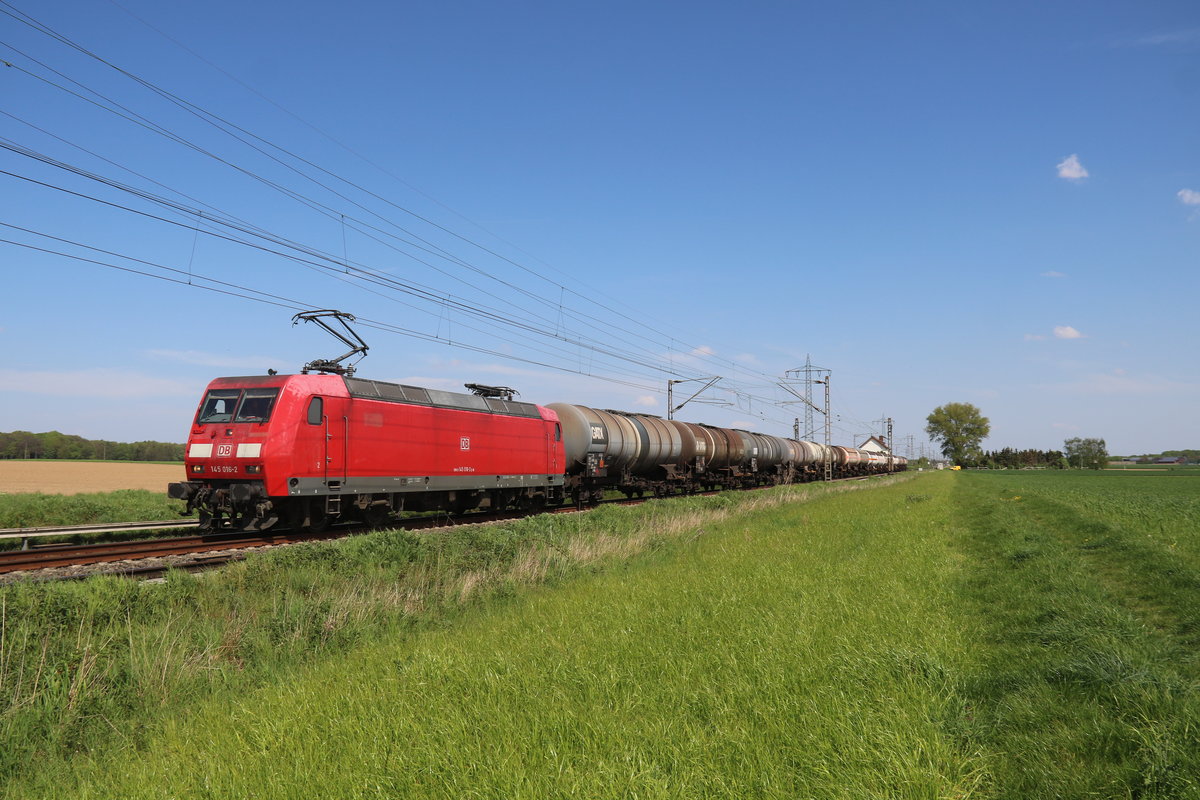145 016 auf dem Weg nach Aachen mit ihrem Kesselzug kurz vor dem kleinen Haltepunkt Herrath im Frühjahr 2019