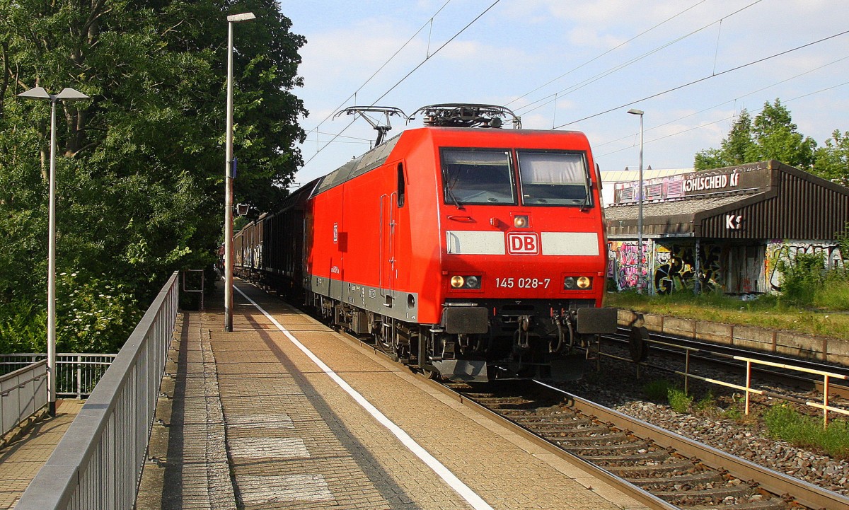 145 028-7 DB kommt durch Kohlscheid mit einem langen Audi-VW-Zug aus Osnabrück nach Kortenberg-Goederen(B) und fährt die Kohlscheider-Rampe hoch nach Aachen-West und fährt in Richtung Richterich,Laurensberg,Aachen-West. 
In der Abendsonne am Abend vom 10.6.2015.