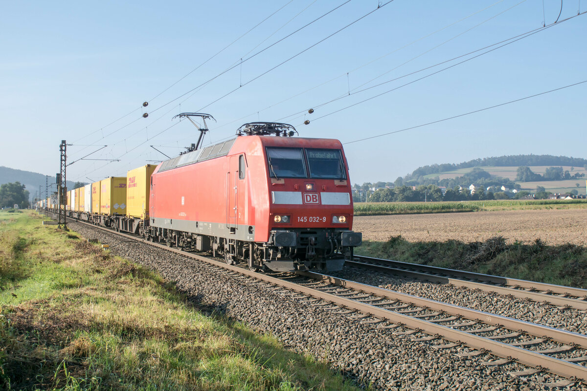 145 032-9 ist mit DHL-Auflieger in Richtung Norden bei Reilos am 08.09.2021 unterwegs.