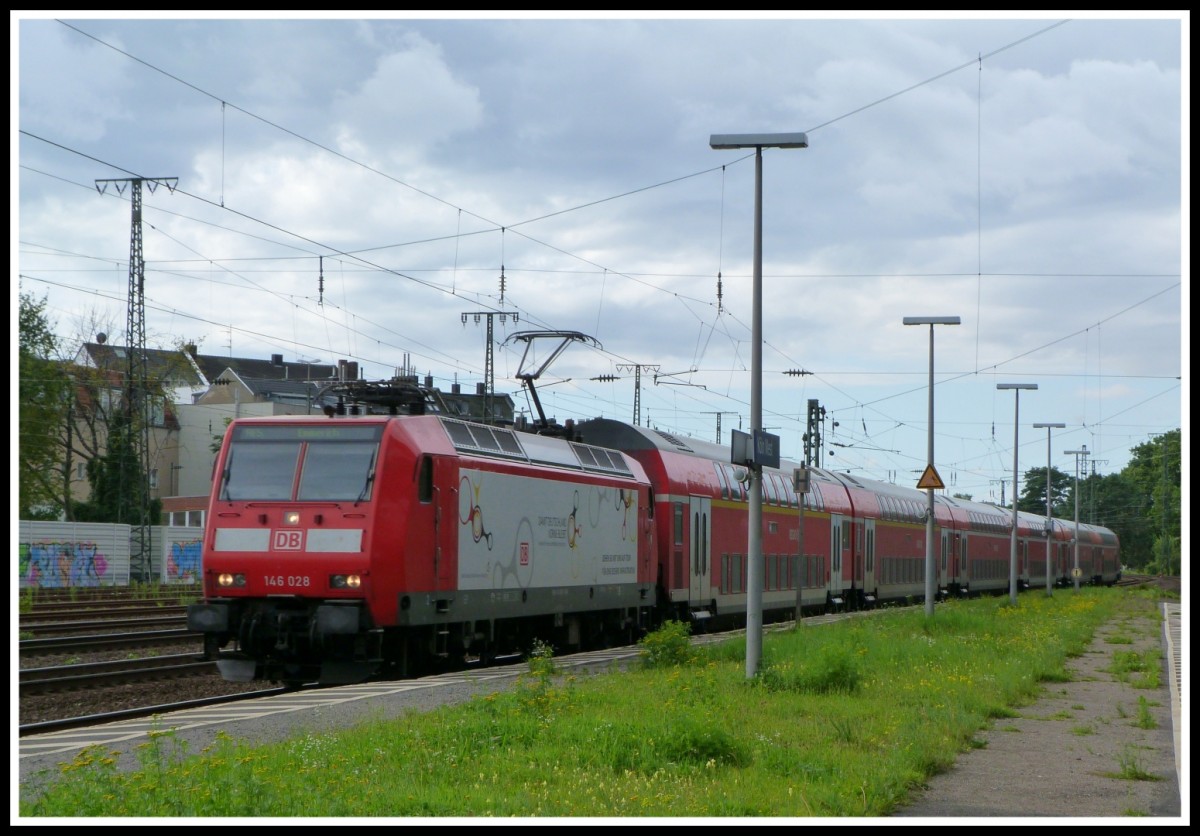 146 028 ist eine von vielen Loks bei DB Regio NRW, welche die Reklame  Damit Deutschland vorne bleibt  besitzt.
Sie fährt am 19.8.14 mit einem RE 5 nach Emmerich durch den Bahnhof Köln West und wird in kürze den Kölner Hbf erreichen. 