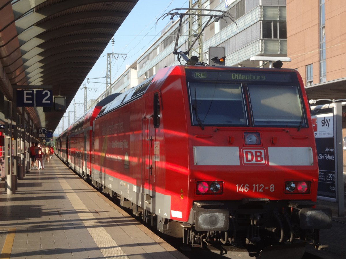 146 112 seht mit einem RE von Basel nach Offenburg in Freiburg(Brsg)Hbf und lässt zwei ICEs durch. (Herbst ´13)