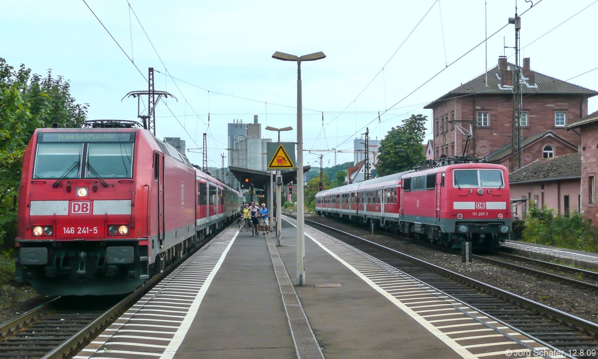 146 241 zog am 12.8.09 Puma-Wagen als RE nach Frankfurt, während 111 207 mit ihrer RB in Karlstadt auf Gleis 1 wendete.
