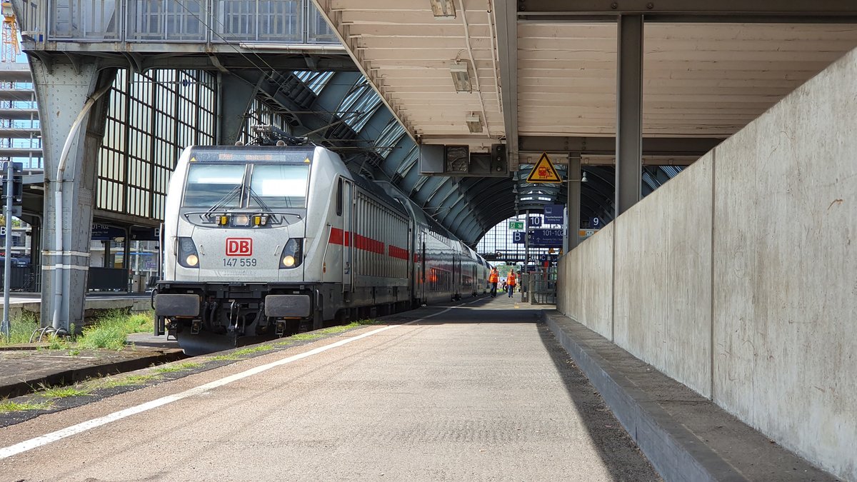 147 559 steht am 9. August 2019 mit einer IC2-Garnitur in Karlsruhe Hbf. Die Front der Lok wird durch das Sonnenlicht betont, während der restliche Zugverband im Schatten steht.