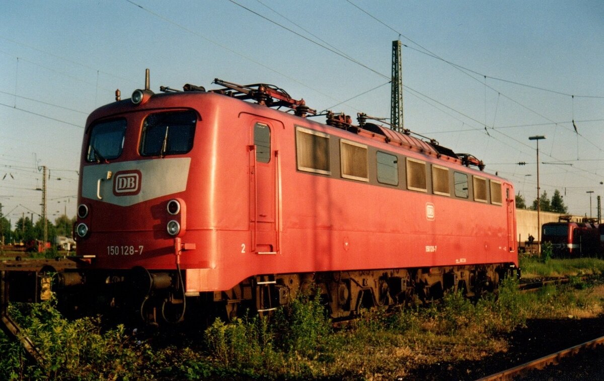 150 128 abgestellt in Hamm (Westfalen). Einst die erste Lok ihrer Baureihe im orientroten Farbkleid. Aufnahme von 1994