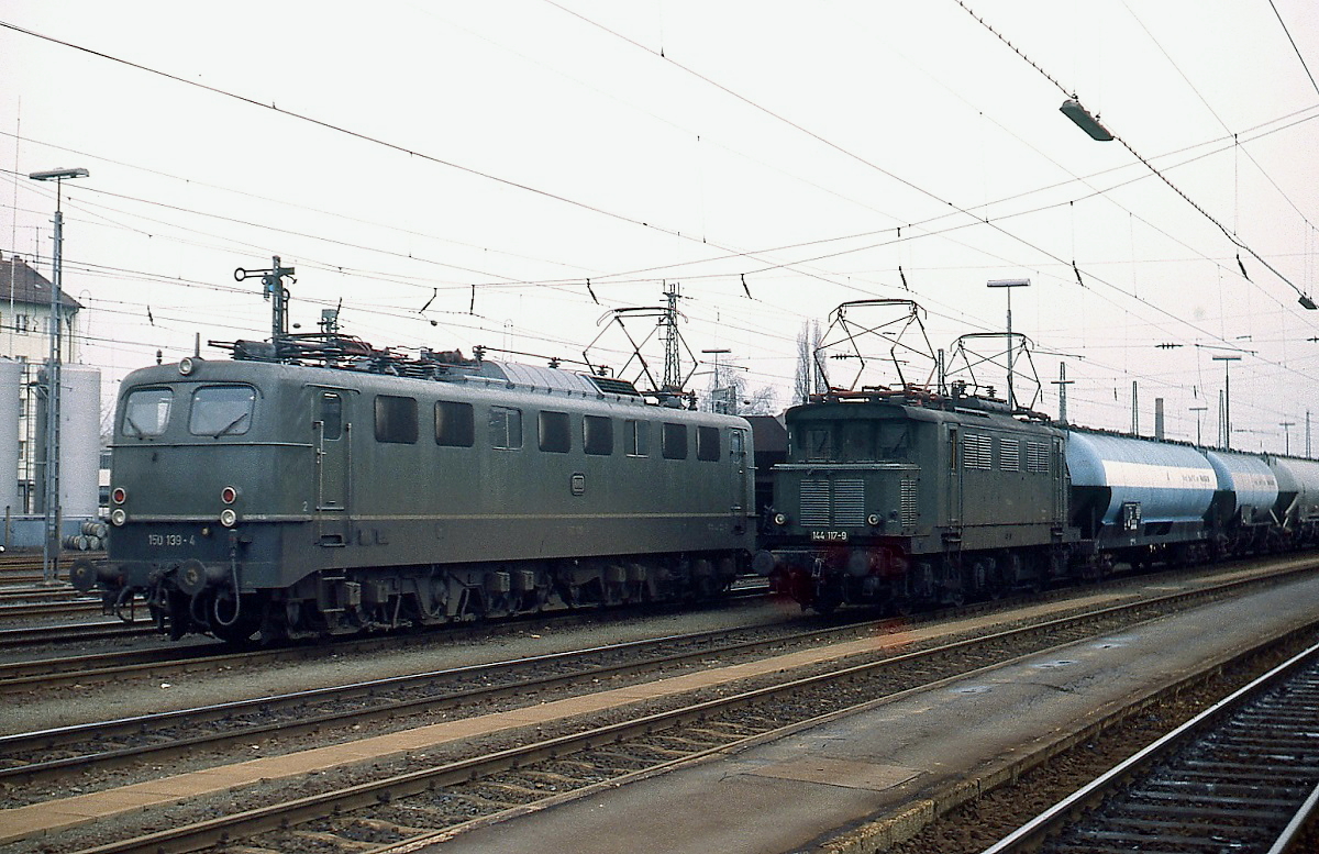 150 139-4 und 144 117-9 warten am 07.04.1979 mit ihren Güterzügen im Bahnhof Bamberg auf die Ausfahrt