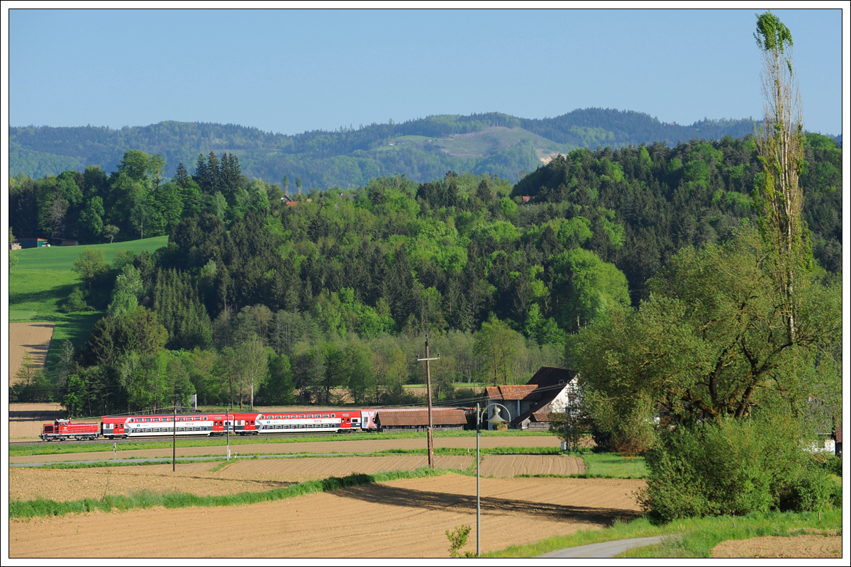 1500.X schieb am 10.5.2021 den R 8569 von Graz Hbf nach Wies-Eibiswald. Die Aufnahme entstand zwischen Pölfing-Brunn und der Haltestelle Wies Markt.