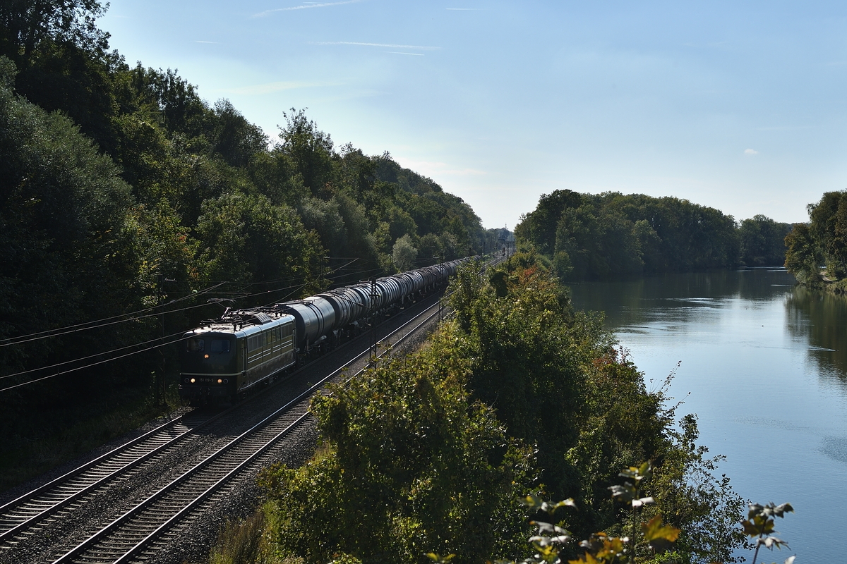 151 119 der BayernBahn zieht am 28. September 2018 einem Kesselwagenzug bei Günzburg die Donau entlang Richtung Neuoffingen.