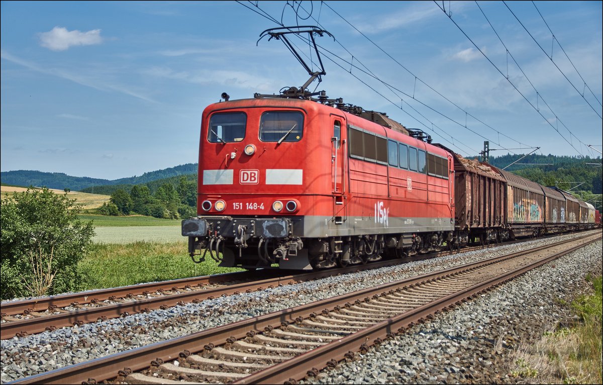 151 148-4 ist mit einen gemischten Güterzug bei Stockheim am 21.06.2017 zu sehen.