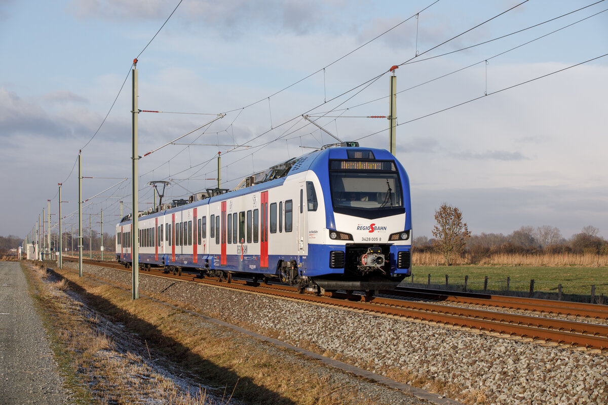 15.12.2022 - Idagroden - Seit dem 12.12.2022 steht die Strecke Oldenburg-Wilhelmshaven unter Strom. Hier ist einer der neuen Züge von Stadler 3428-005 (Nordwestbahn) als Betriebsfahrt auf dem Weg von Wilhelmshaven in Richtung Oldenburg.