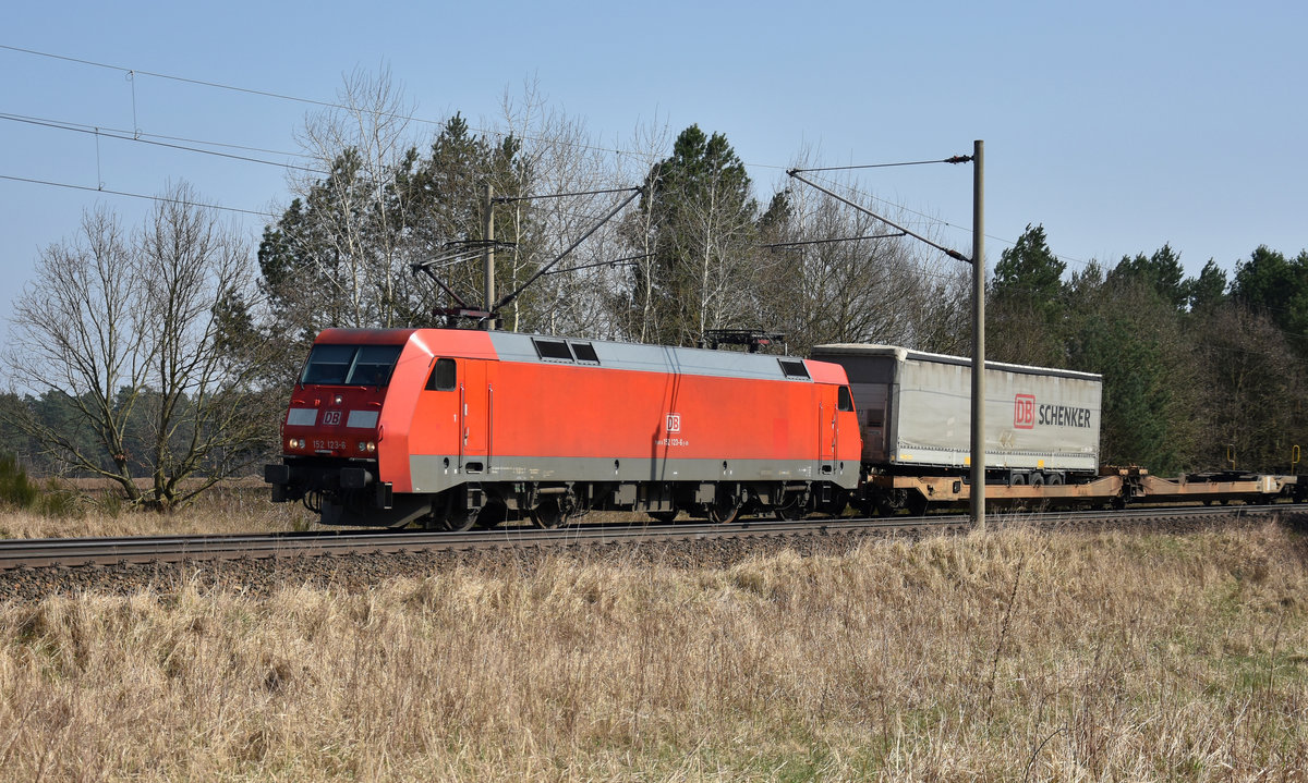 152 123-6 der DB kommend aus dem Hagenower Land mit halbvollen/leeren Sattelzug-Güterwaggons. 10.04.2018, 3km östlich von Büchen.