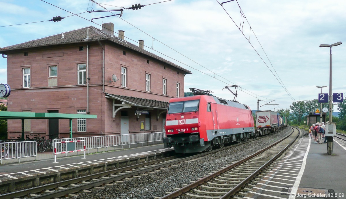 152 153 legte sich am 12.8.09 um 15.37 Uhr mit einem Güterzug in Retzbach-Zellingen vor dem Empfangsgebäude in die Kurve. 