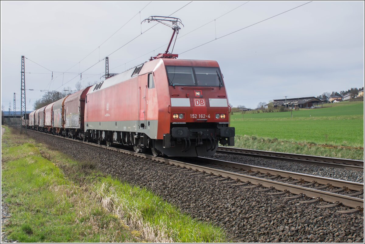 152 162-4 fährt mit einem kurzen Güterzug in Richtung Fulda gesehen am 26.03.2024 bei Kerzell.