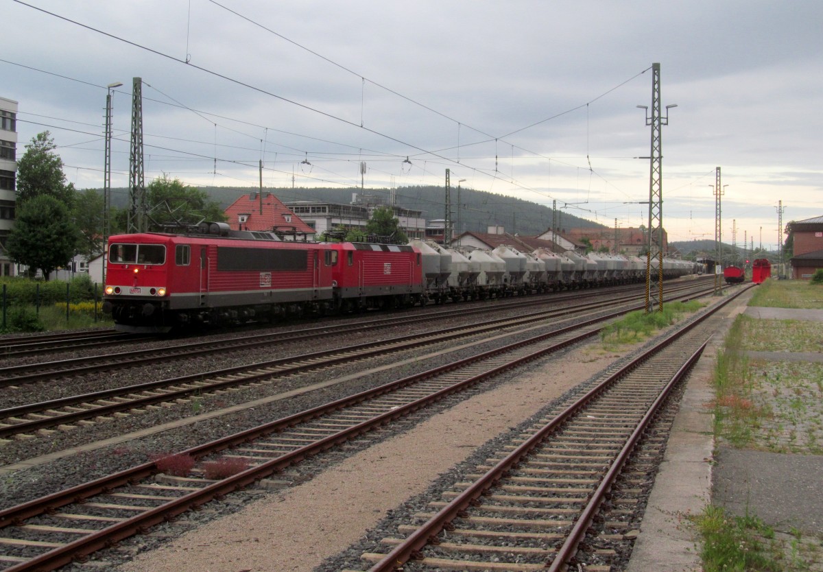 155 119-1 (MEG 706) und 143 257-4 (MEG 604) ziehen am 19. Juni 2014 einen Zementzug durch Kronach in Richtung Saalfeld.