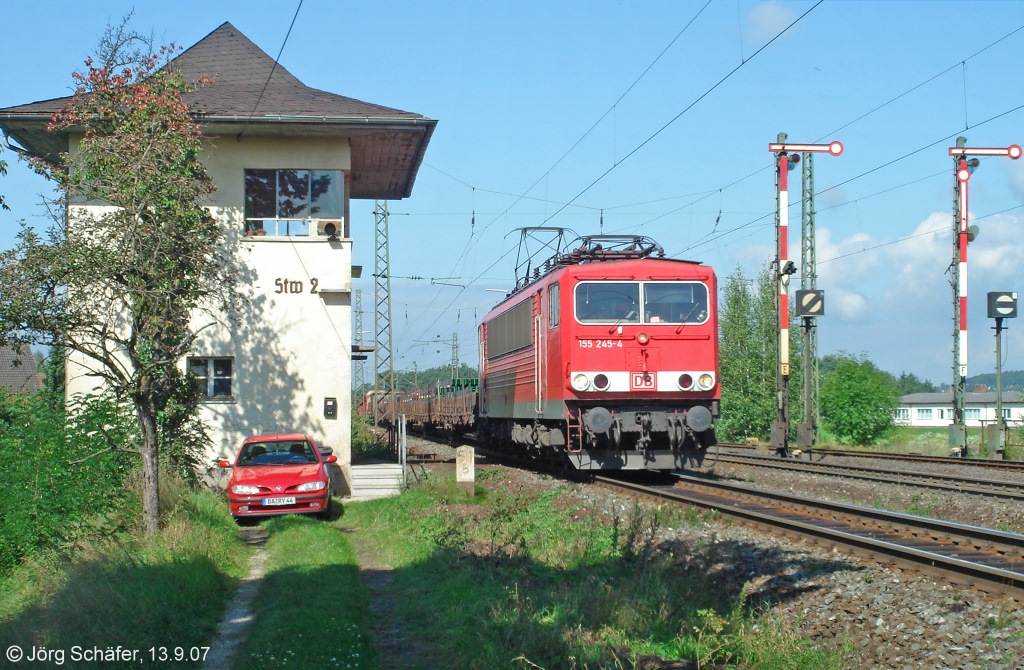 155 245 passierte am 13.9.07 mit einem Flachwagenzug Richtung Nürnberg im Bahnhof Hirschaid das Wärter-Stellwerk 2. Rechts die Form-Ausfahrsignale nach Strullendorf.