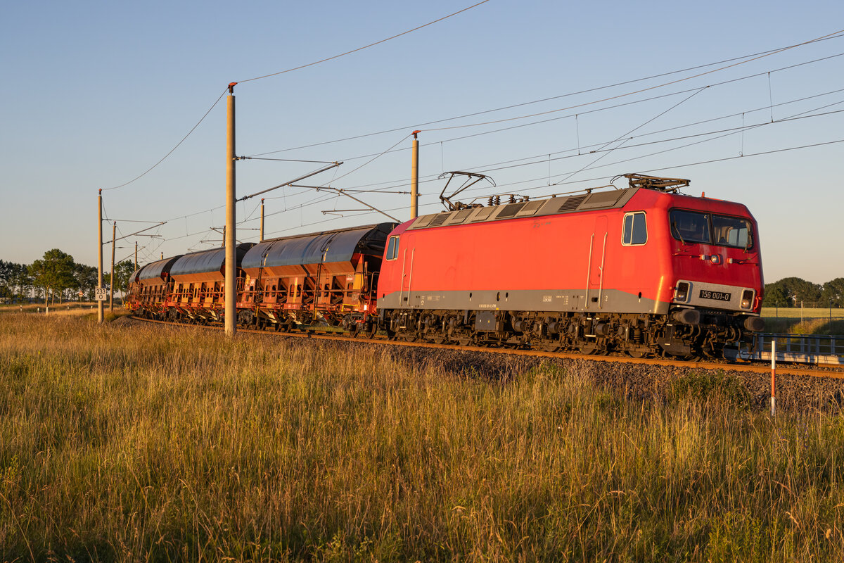 156 001 mit einem leeren Getreidezug von Mukran nach Freiberg. Aufgenommen zwischen Rambin und Altefähr um 21.07 Uhr am 23.06.2022.
