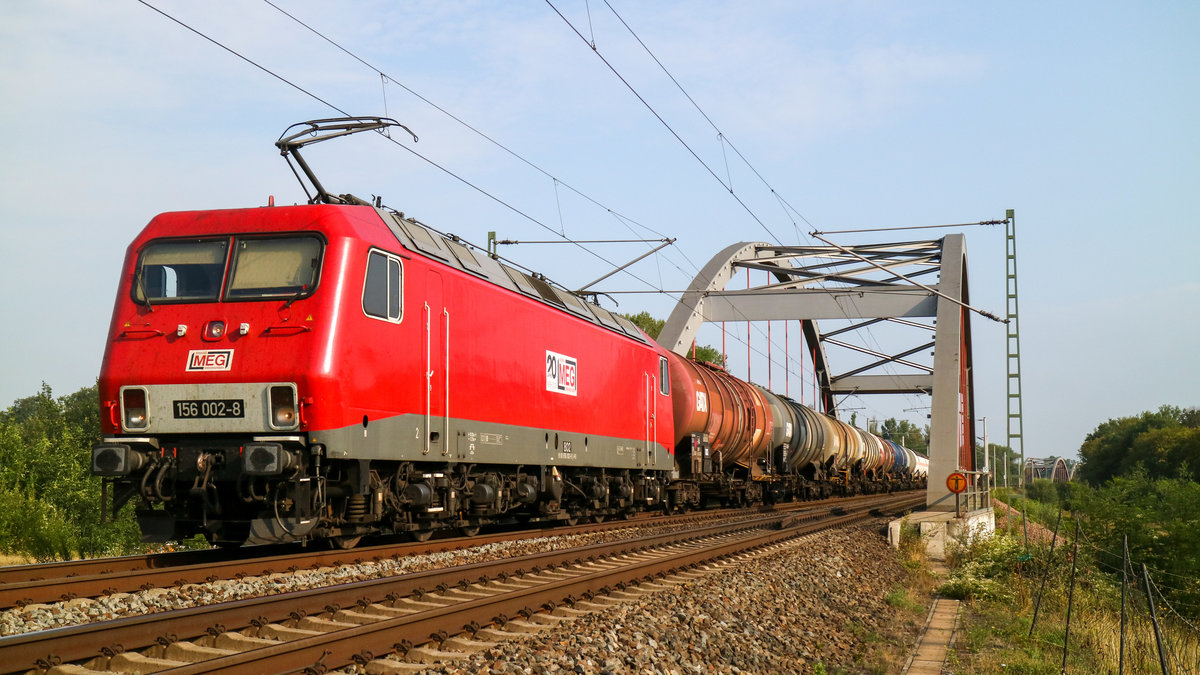 156 002 mit einem Kesselzug fährt gerade über die Peiskerbrücke nach Dessau ein. (03.08.2019)