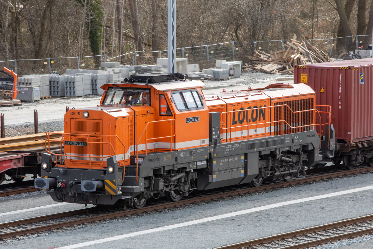 16.3.2021 - Vossloh DE18 von LOCON vor einem Containerzug im Sander Bahnhof. Der Zug fährt Richtung Jade-Weser-Port. Fotografiert von der Aussichtsplattform im Bahnhof.