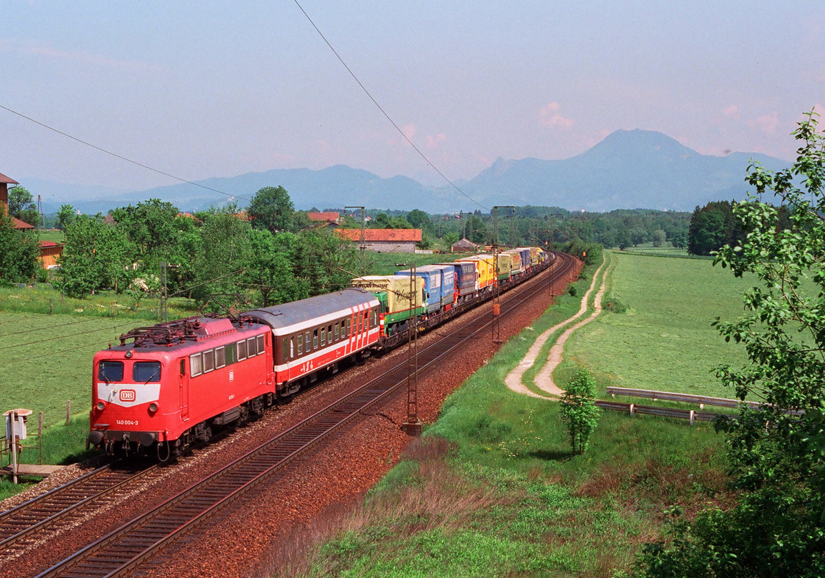17.Mai 1993 auf der Strecke Freilassing-Rosenheim ist die  Rollende Landstraße  mit  140 004-3 unterwegs.