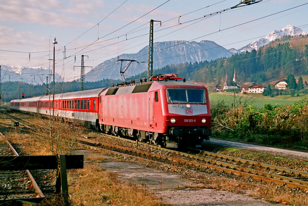 18. März 2000, IC „Alpenland“, hier, in Hammerau noch als RB eingestuft, fährt nach Freilassing. Lok 120 123 vor idyllischer Bergkulisse.