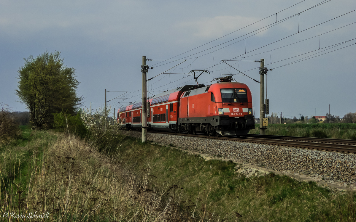 182 023 zieht ihren Doppelstock-Wendezug als S2 von Delitzsch nach Leipzig-Connewitz. Der Zug erreicht in Kürze den Haltepunkt Zschortau. (09.04.2016)