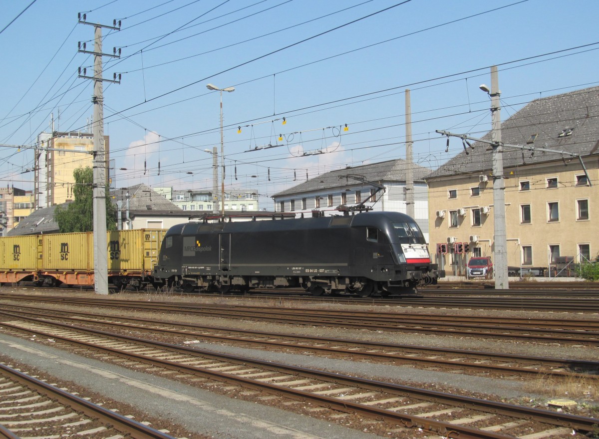 182 537-1 von MRCE zieht am 06. August 2013 einen Containerzug durch Linz in Richtung Wels.