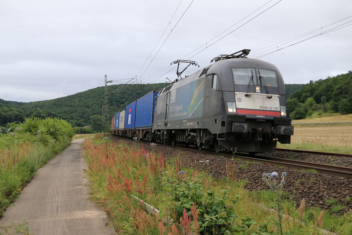 182 567 (ES 64 U2-067) mit ETCS-Trainguard Seitenwerbung bespannte am 10.07.2014 einen Containerzug in Fahrtrichtung Süden. Aufgenommen bei Harrbach.